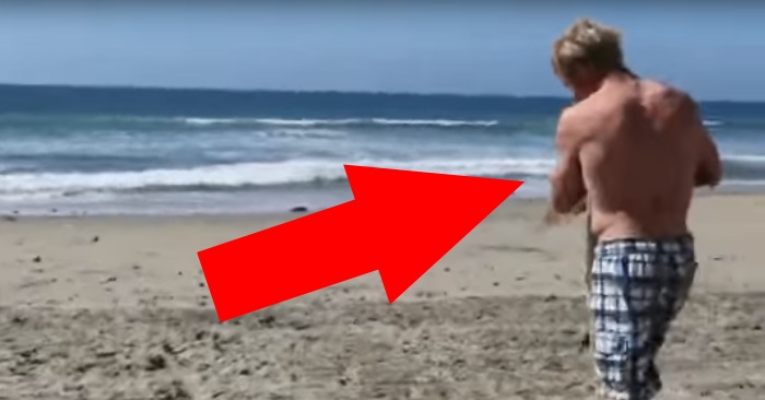 Han plukker opp kameraet når mannen løper mot havet. Men SE hva han holder i armene!